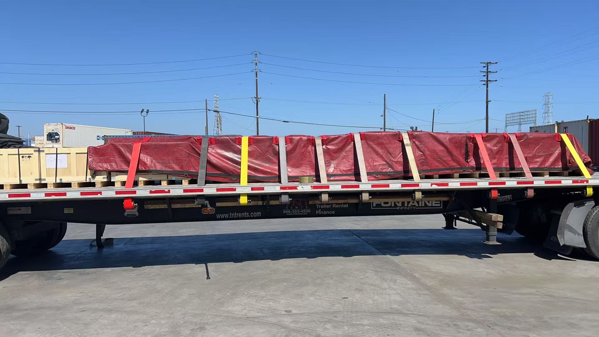Flatbed departure — chain-lashed cargo